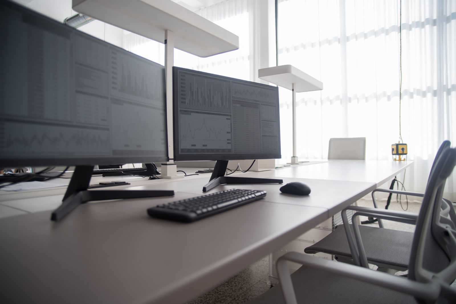 An accountant's desk with two monitors in a quiet office