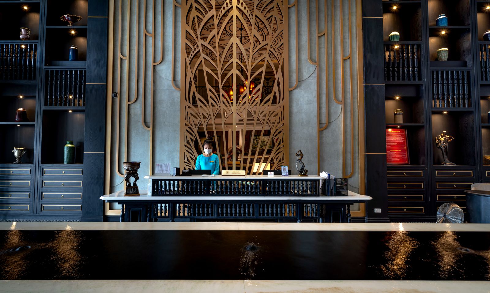 A receptionist at the front desk of a hotel lobby