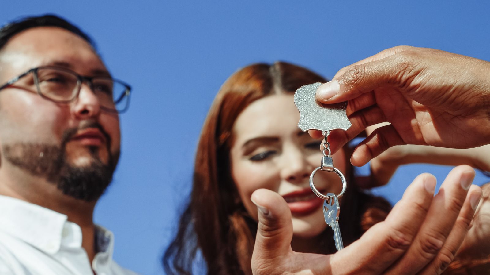 A real estate agent handing house keys to a buyer