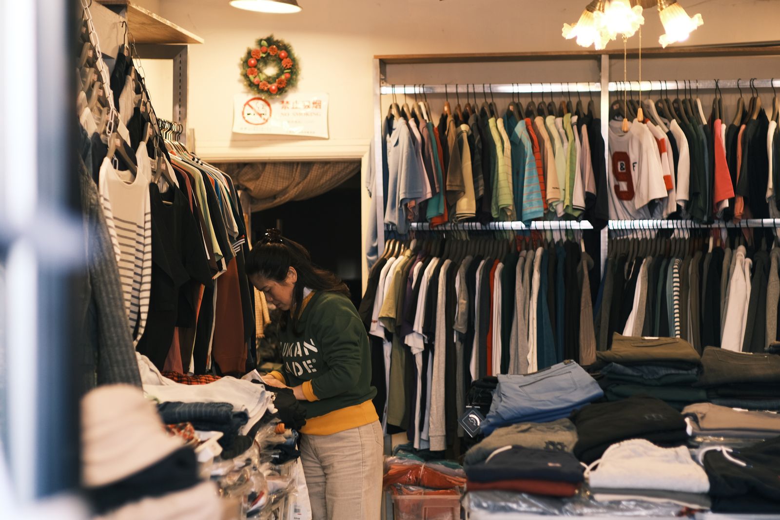 A shop owner sorting stock in a small clothing boutique